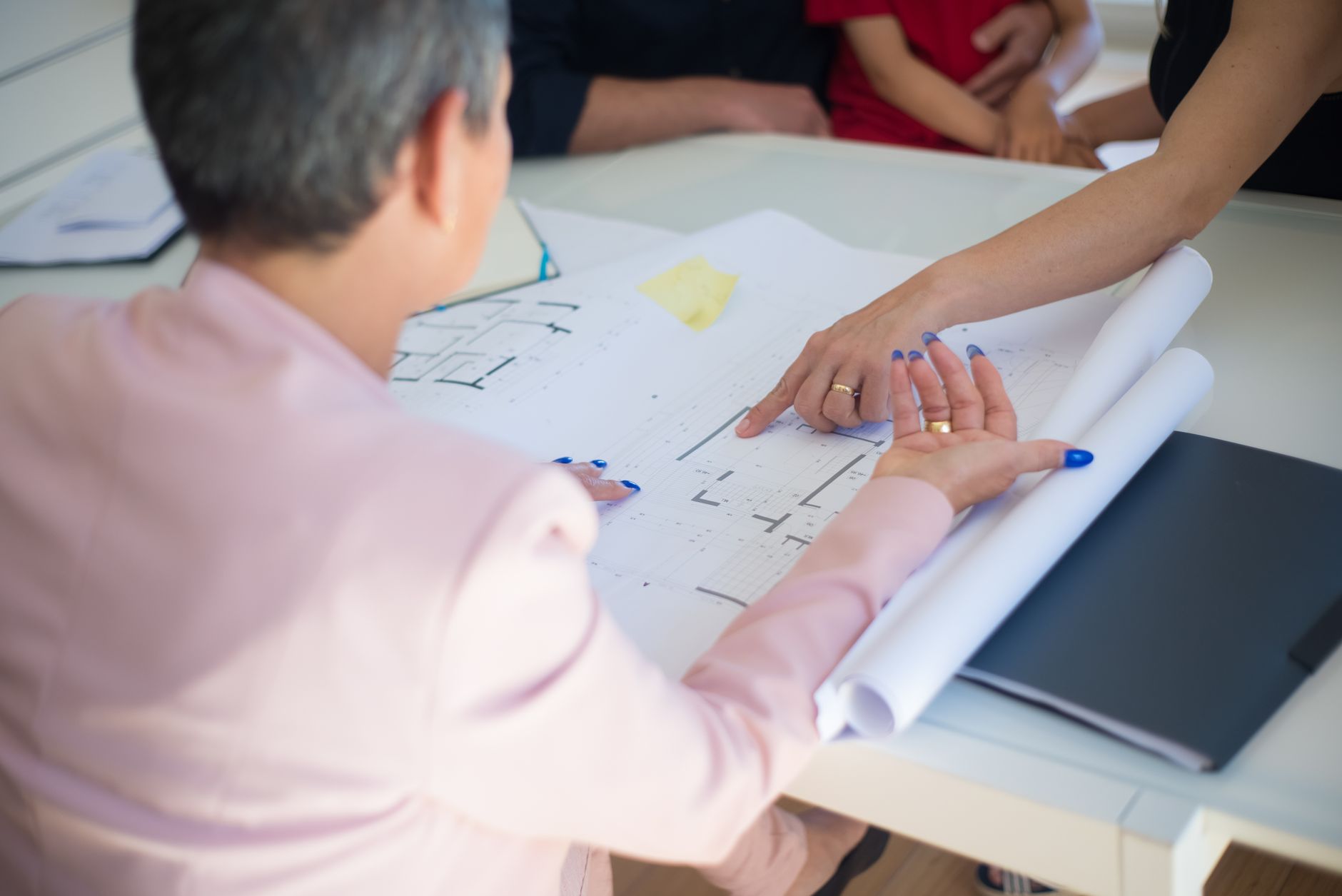 Team reviewing blueprints around a table